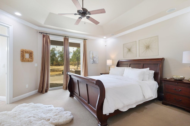 carpeted bedroom featuring ceiling fan, ornamental molding, and a tray ceiling