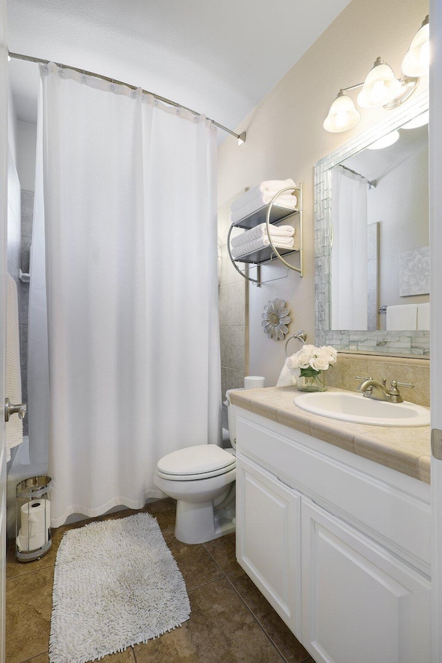 bathroom featuring vanity, a shower with shower curtain, toilet, and tile patterned flooring