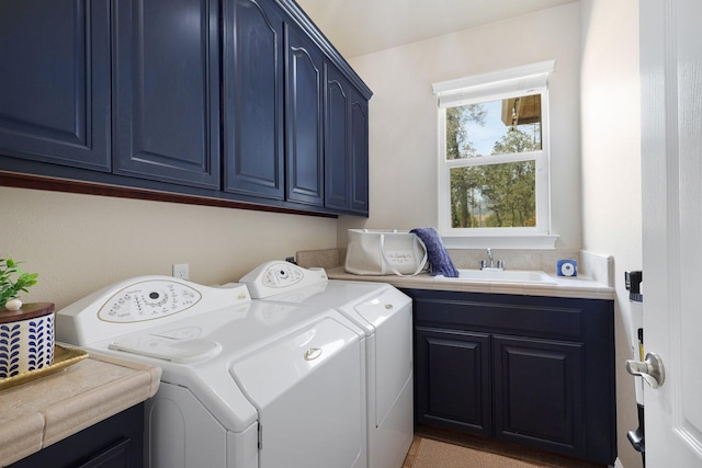 clothes washing area featuring cabinets, sink, and washing machine and clothes dryer