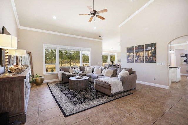 living room featuring crown molding, light tile patterned floors, a high ceiling, and ceiling fan