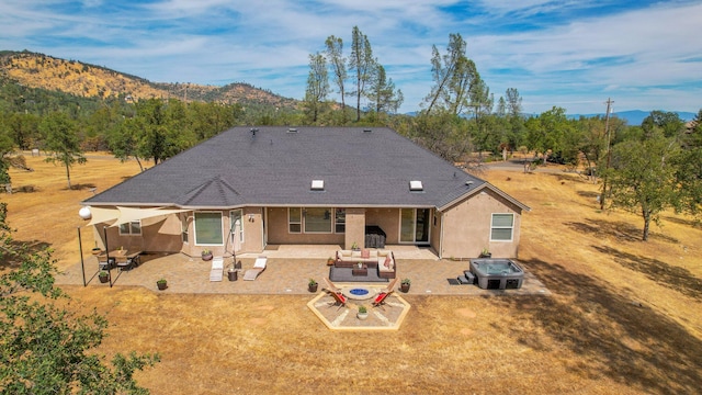 rear view of property with a patio area, a mountain view, a lawn, and an outdoor hangout area