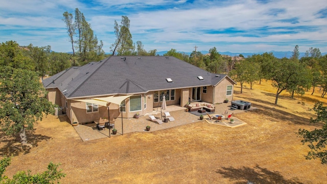 back of property with an outdoor living space and a patio