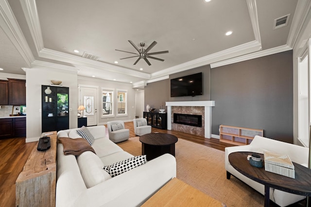 living room with a tray ceiling, wood-type flooring, and ceiling fan