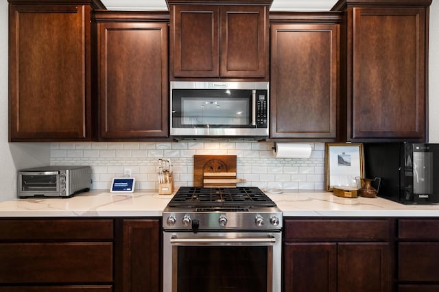 kitchen featuring appliances with stainless steel finishes, tasteful backsplash, and light stone counters