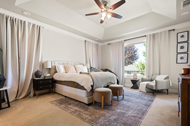 bedroom featuring a raised ceiling, ceiling fan, ornamental molding, and light colored carpet