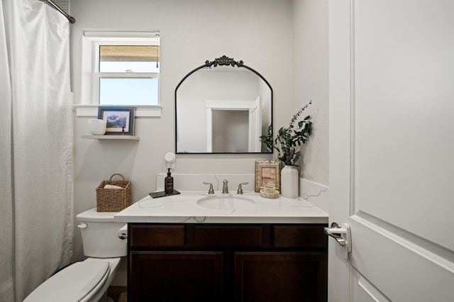 bathroom with curtained shower, toilet, and vanity