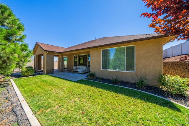 rear view of property featuring a patio area and a lawn