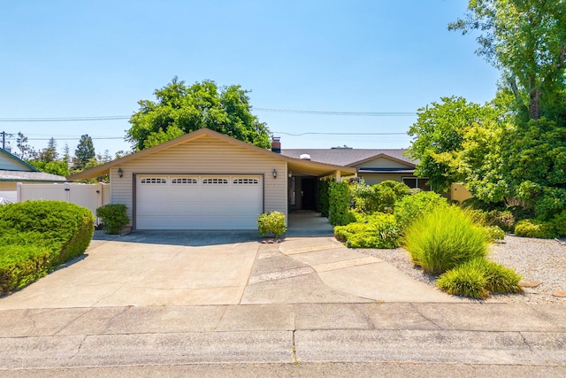 ranch-style house with fence, a garage, and driveway