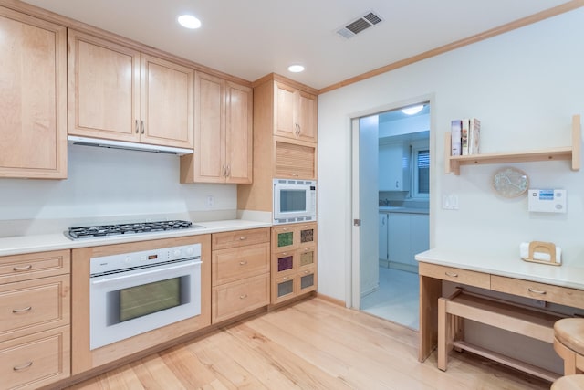 kitchen featuring white appliances, light hardwood / wood-style flooring, light brown cabinetry, and sink