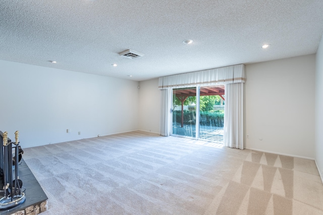 unfurnished living room featuring a textured ceiling and light carpet