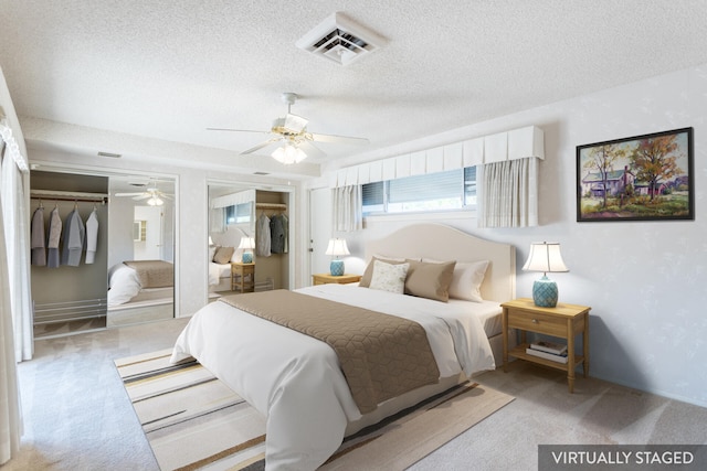 bedroom with ceiling fan, light colored carpet, and a textured ceiling