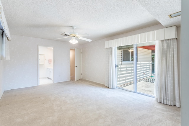 unfurnished room with a textured ceiling, light colored carpet, and ceiling fan