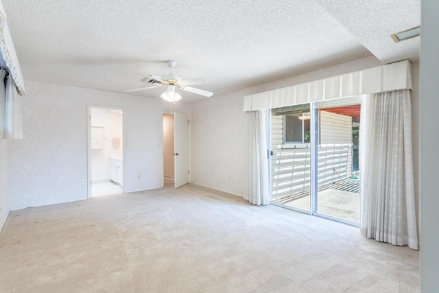 carpeted empty room featuring visible vents, a textured ceiling, and ceiling fan