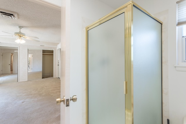 corridor with carpet flooring and a textured ceiling