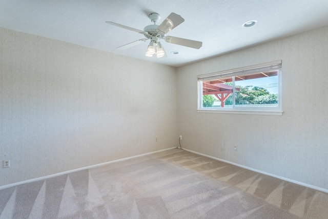 carpeted spare room featuring ceiling fan