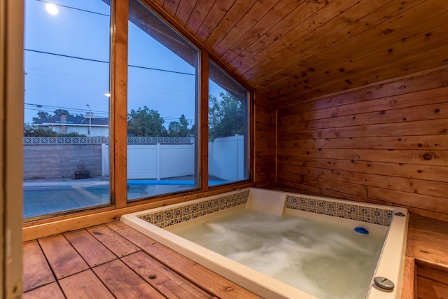 interior space with lofted ceiling, hardwood / wood-style floors, wooden walls, and wooden ceiling