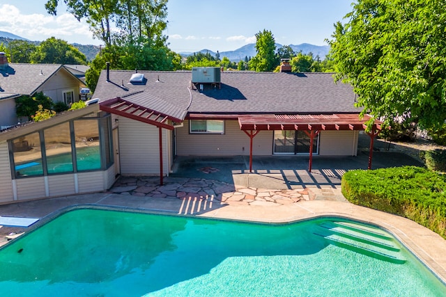 view of swimming pool with central AC, a mountain view, and a patio area