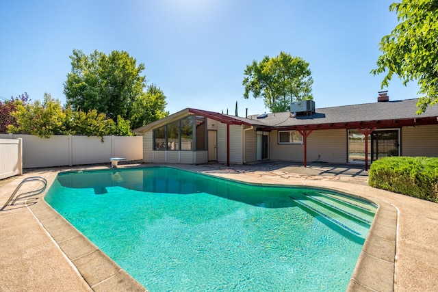 pool featuring a diving board, central air condition unit, fence, and a patio area