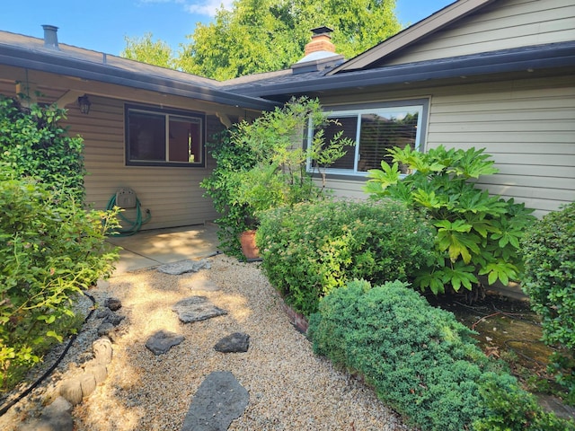 doorway to property featuring a patio area and a chimney