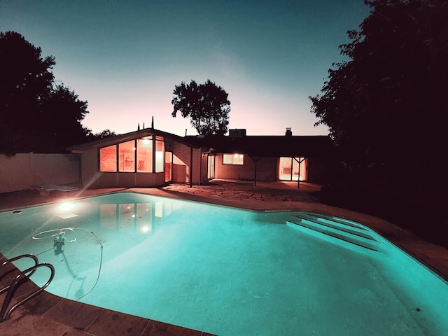 pool at dusk with a patio