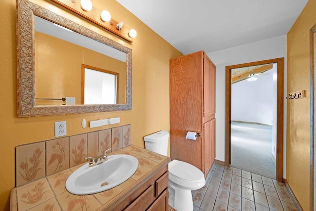 bathroom with ceiling fan, vanity, toilet, and tile patterned floors