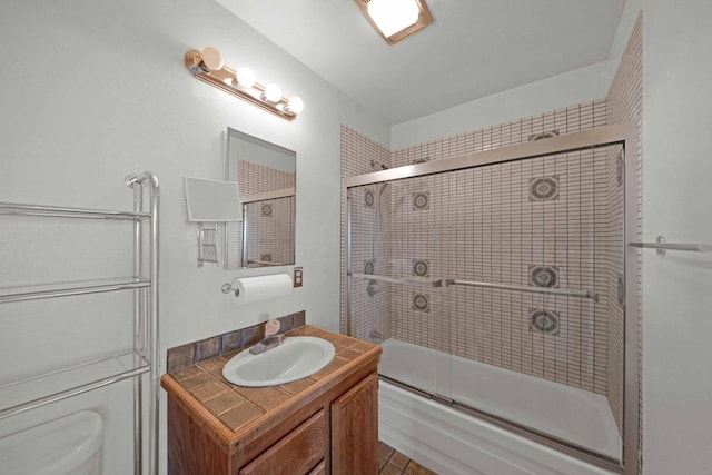 full bathroom featuring enclosed tub / shower combo, vanity, and toilet