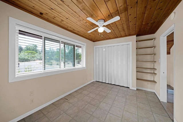 unfurnished bedroom with wood ceiling, multiple windows, light tile patterned floors, and ceiling fan