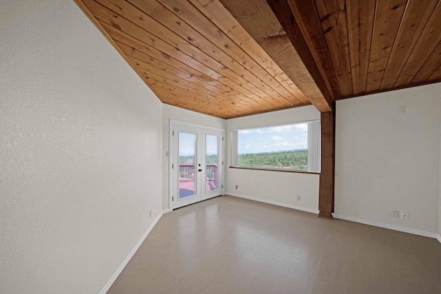 unfurnished room featuring lofted ceiling with beams, wood-type flooring, wooden ceiling, and french doors