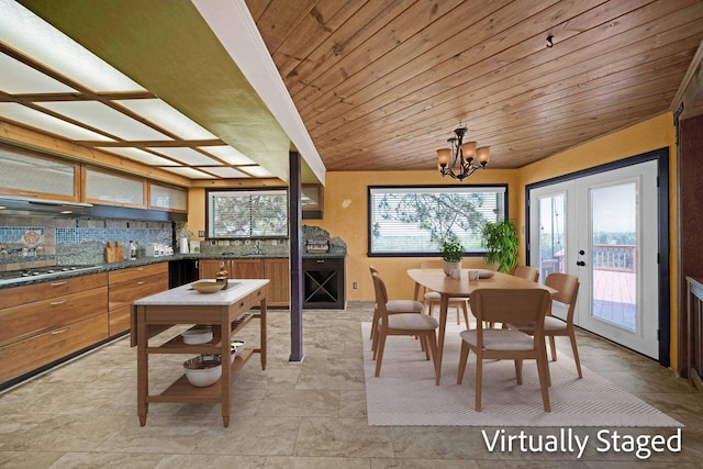 tiled dining space featuring an inviting chandelier, a wealth of natural light, and french doors