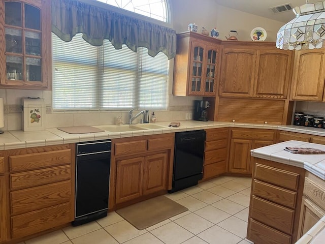 kitchen featuring dishwasher, light tile patterned flooring, and tile counters