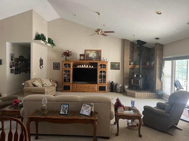 living room featuring a wood stove, ceiling fan, carpet floors, and lofted ceiling