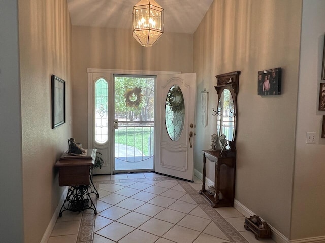 tiled foyer with lofted ceiling and a chandelier