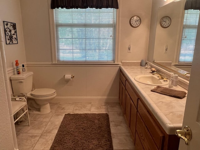 bathroom featuring vanity, toilet, plenty of natural light, and tile patterned flooring