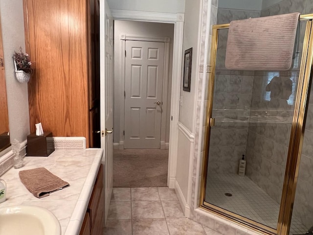 bathroom featuring tile patterned flooring, a shower with door, and vanity