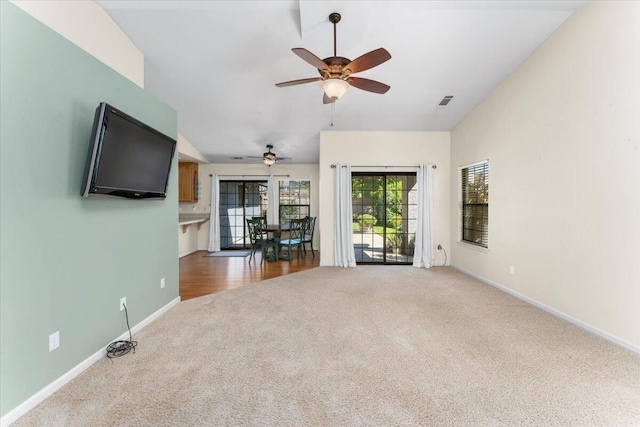 unfurnished living room featuring carpet and ceiling fan