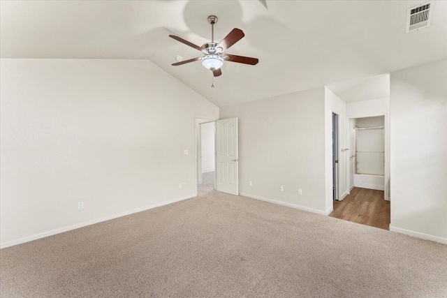 interior space featuring ceiling fan, light colored carpet, and lofted ceiling