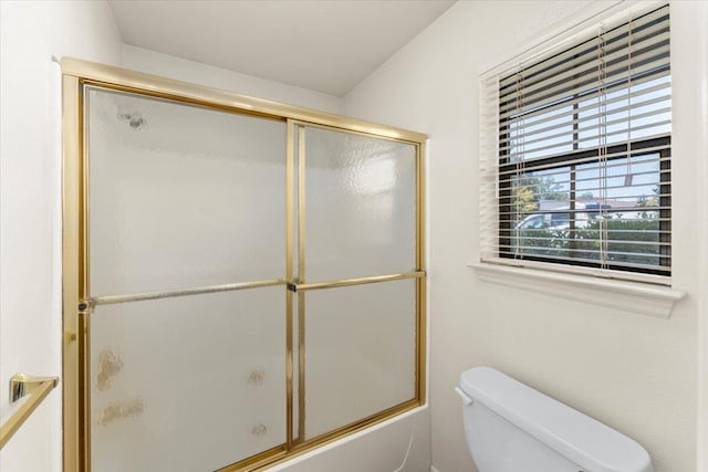 bathroom featuring shower / bath combination with glass door and toilet