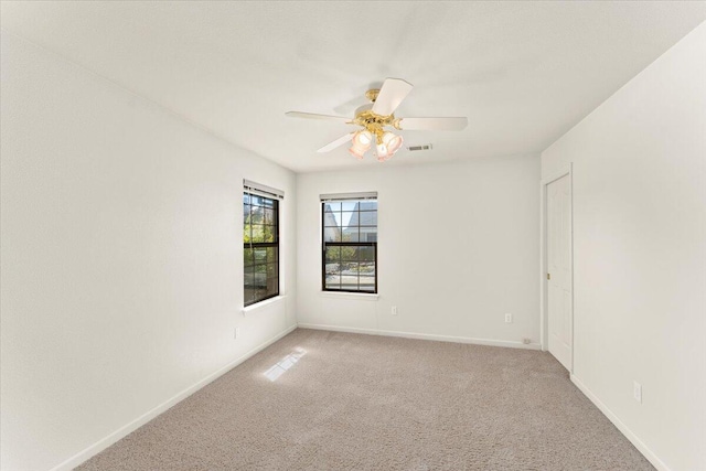 empty room featuring light colored carpet and ceiling fan