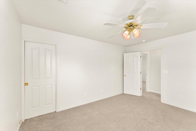 empty room featuring ceiling fan and light carpet