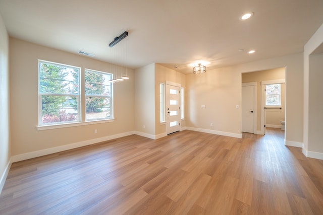 unfurnished room with light wood-type flooring and a healthy amount of sunlight