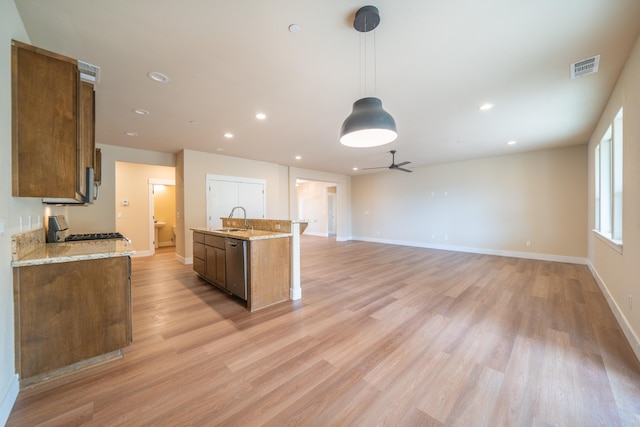 kitchen with ceiling fan, stove, hanging light fixtures, sink, and light hardwood / wood-style flooring