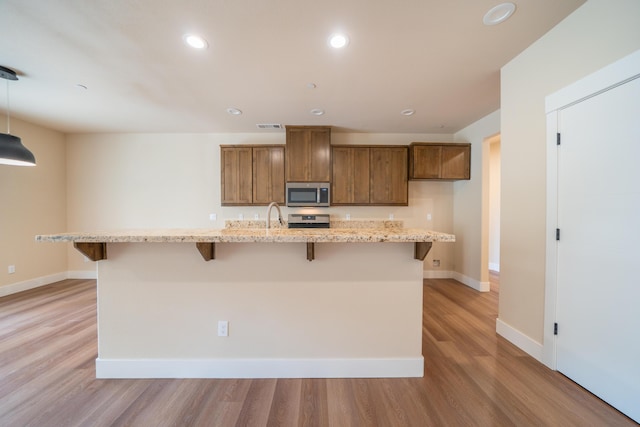 1132 Kellinger St, Redding, CA 96003 - kitchen with recessed lighting, light wood-type flooring, appliances with stainless steel finishes, and a breakfast bar area