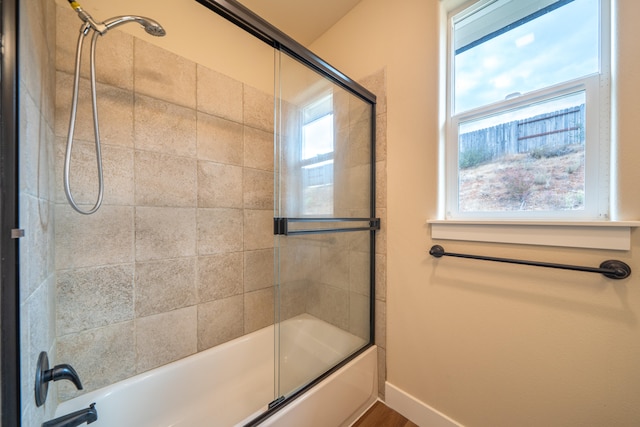 bathroom featuring bath / shower combo with glass door