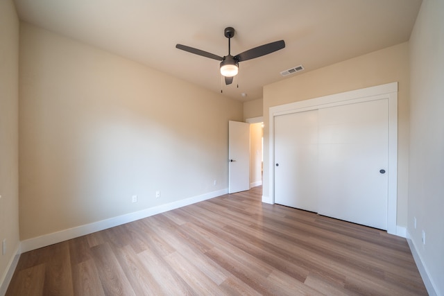 unfurnished bedroom featuring a closet, light hardwood / wood-style floors, and ceiling fan