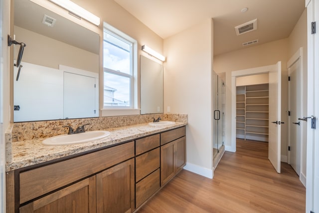 bathroom featuring walk in shower, vanity, and hardwood / wood-style flooring