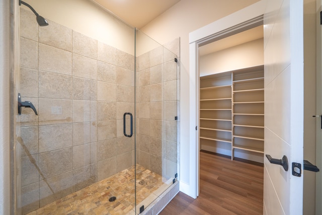 bathroom with an enclosed shower and hardwood / wood-style floors