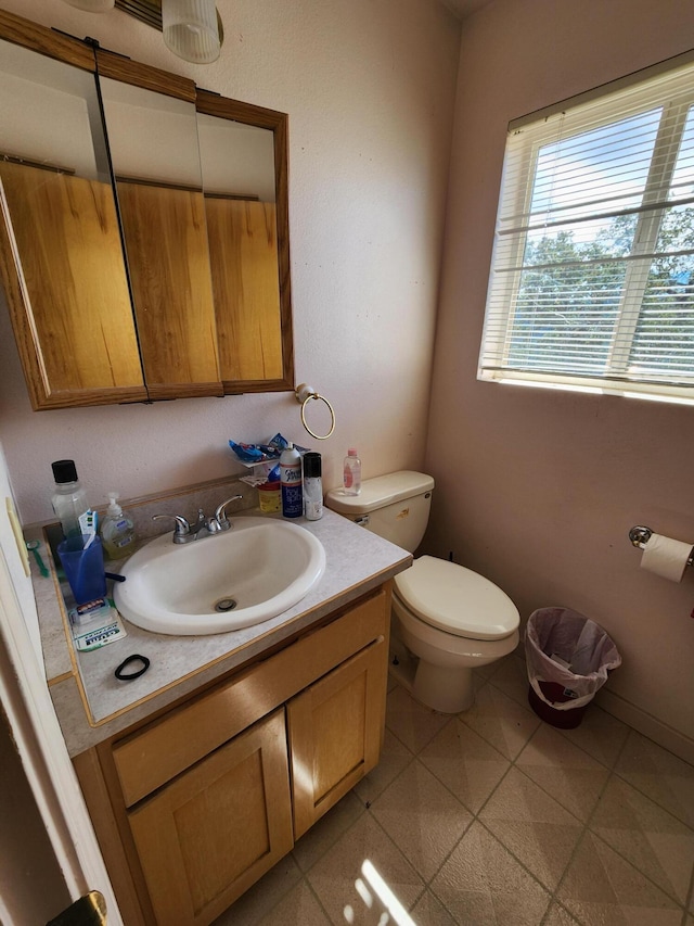 bathroom with vanity, toilet, and tile patterned flooring