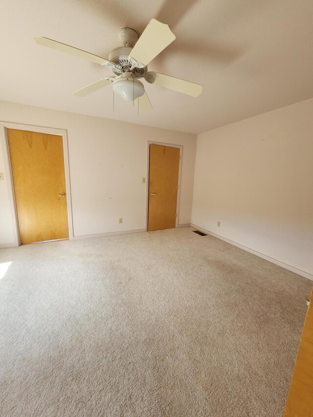 carpeted spare room featuring ceiling fan