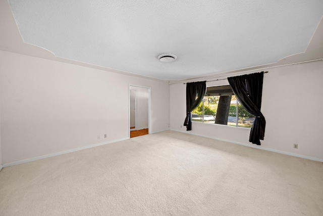 unfurnished room featuring light carpet and a textured ceiling