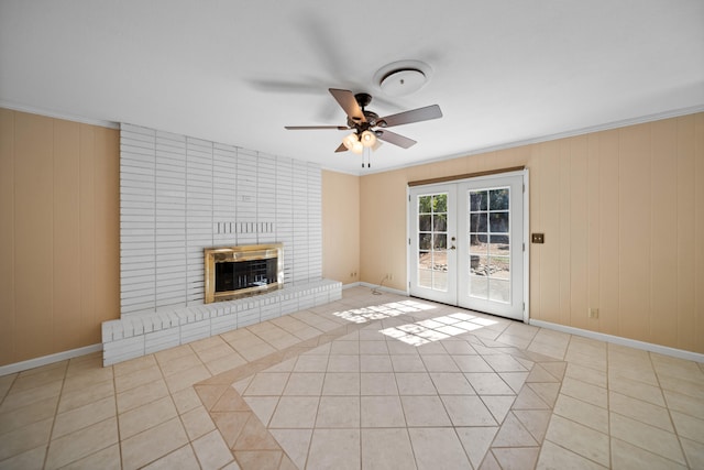 unfurnished living room featuring ceiling fan, ornamental molding, light tile patterned floors, french doors, and a fireplace